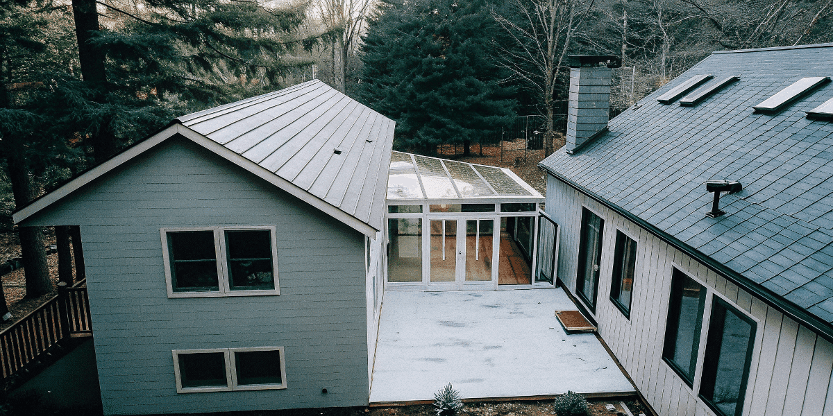 2a69737b37594c44a90791682b1850c3 Aerial view of tiny houses connected by a sunroom