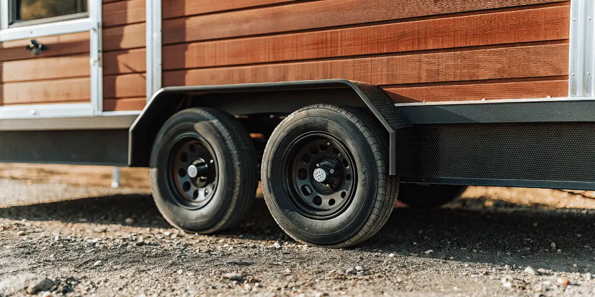Aa6146ca143d4d269cd409c7efc71e2f Close up of a tiny house trailer showing wheels and foundation