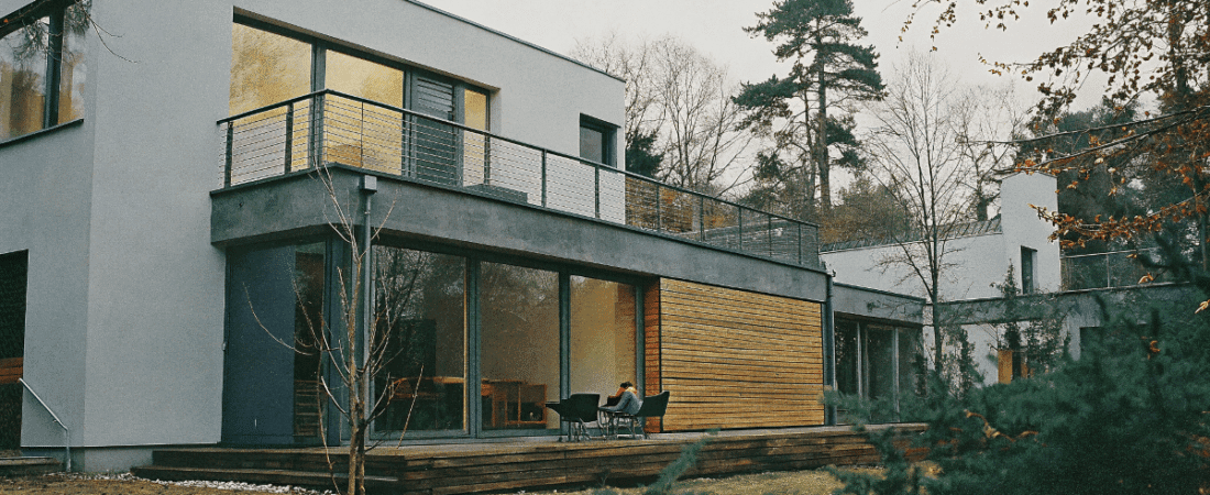 A white Contemporary prefab home surrounded by trees