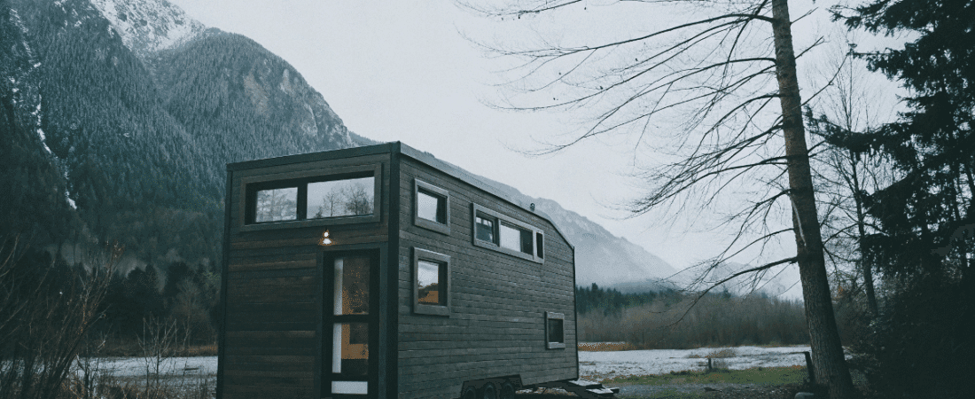 Modern tiny house on wheels with mountain backdrop