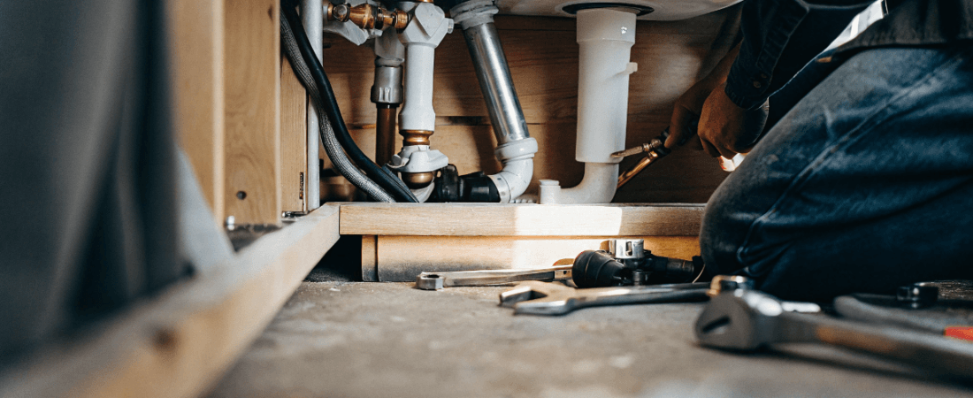 A photo of a scene in a plumbing area with a focus on the intricate network of pipes and fittings