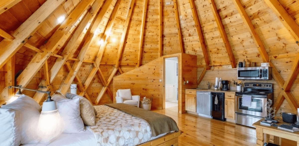 14d7dd8ae51e4af99304ea81d5f2eb01 Interior of a wooden yurt with bed oven and microwave