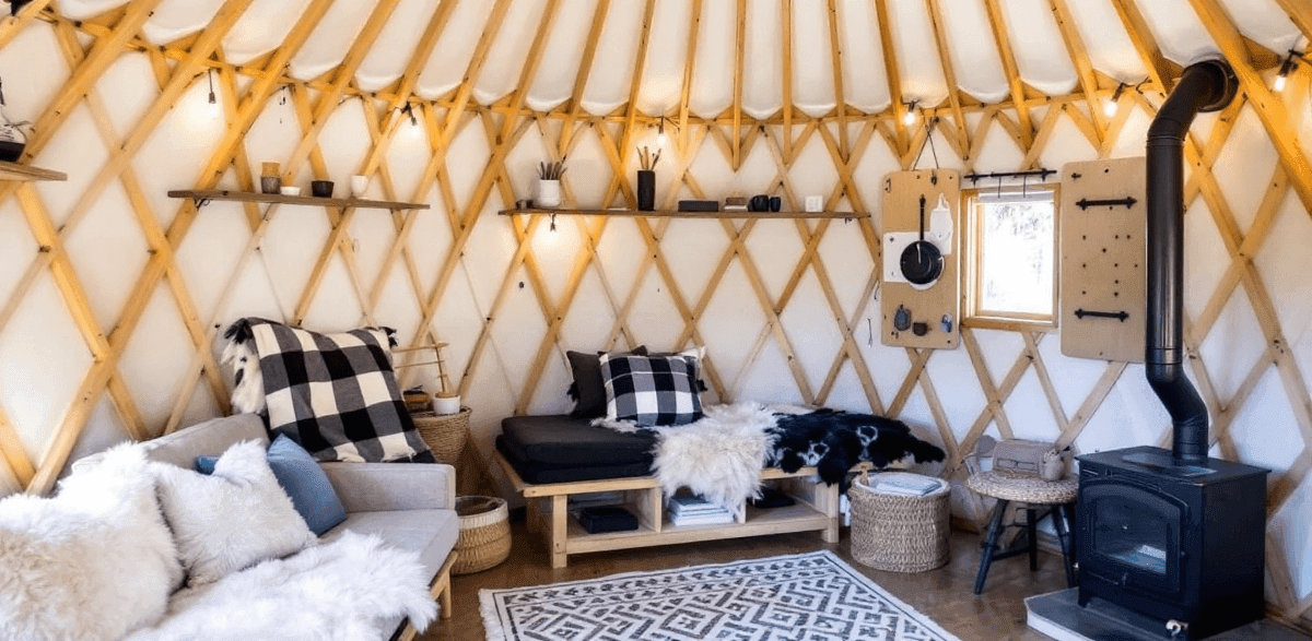 94a06d20989946c4be2026e1b7643ba5 A photo featuring a cozy and traditional wooden style interior of a thatched roof dwelling commonly known as a yurt