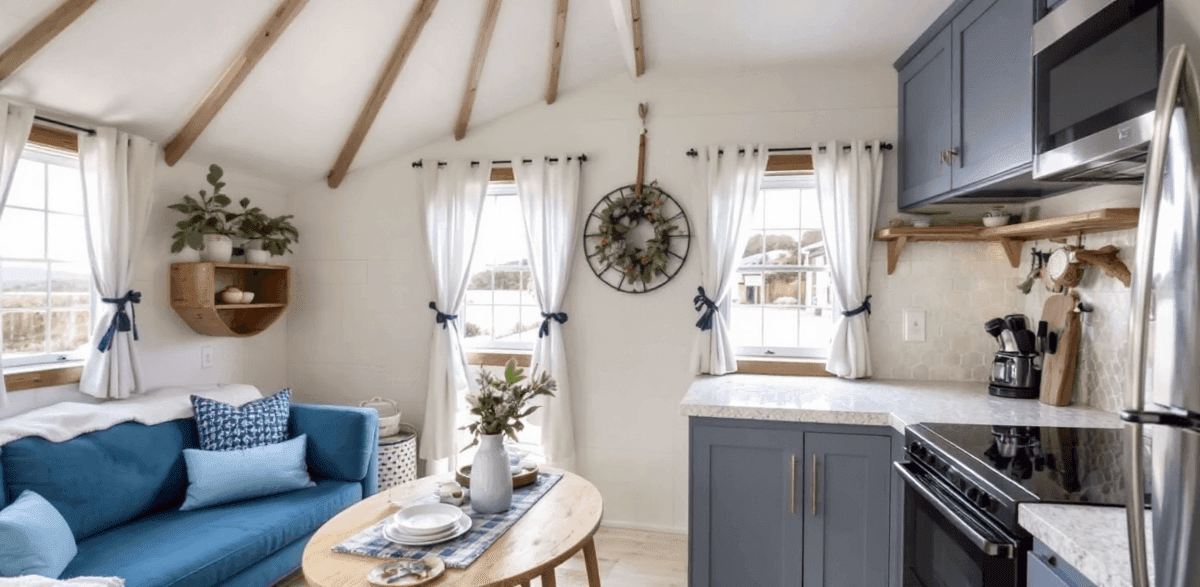 9c4b885dce5540c992972643f871781e An interior of a cozy coastal cottage yurt with sofa kitchen cooker and sink