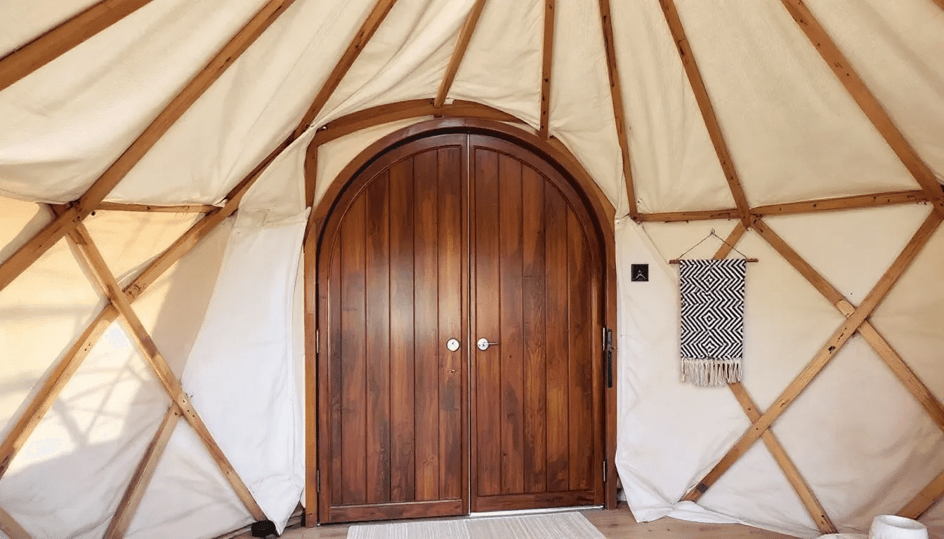 Eb9b29886bdd40888f0c7cb8e29c8ec8 A modern yurt interior features an open floor plan with large windows that flood the living space with natural light showcasing a cozy main room with a wood burning stove and minimalist furniture The design incorporates a bedroom loft and rustic elements creating a harmonious blend of traditional yurt living and contemporary aesthetics