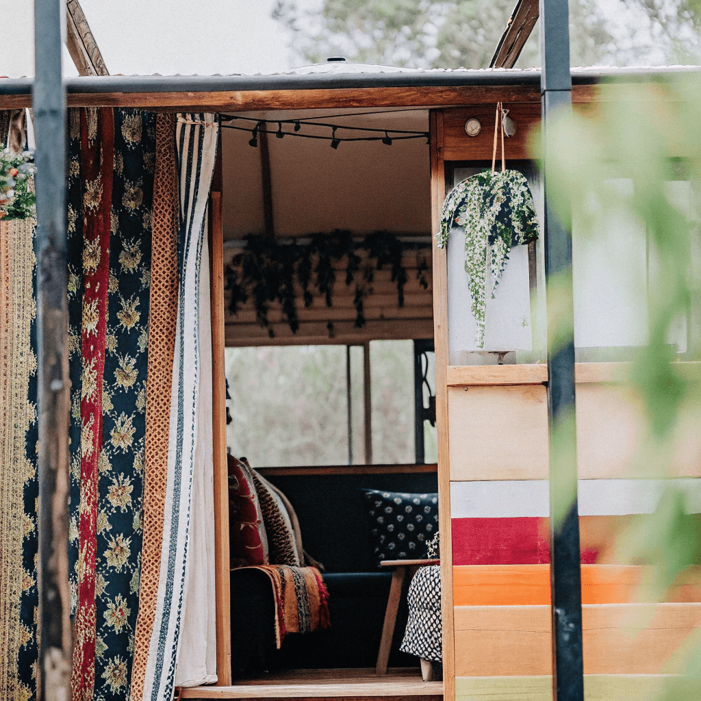 Bohemian tiny house on wheels Boho style tiny house on wheels with plants and fabrics