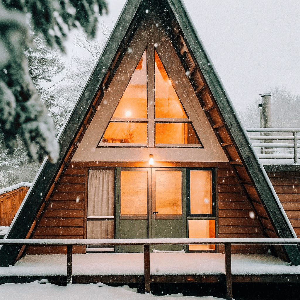 Tiny a frame cabin A frame tiny home in snowy landscape with lights on