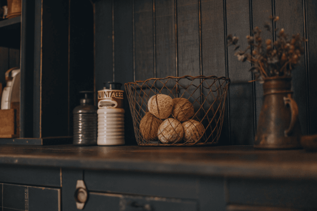 Farmhouse laundry room countertop with vintage jars wire basket potted plant and decorative sign