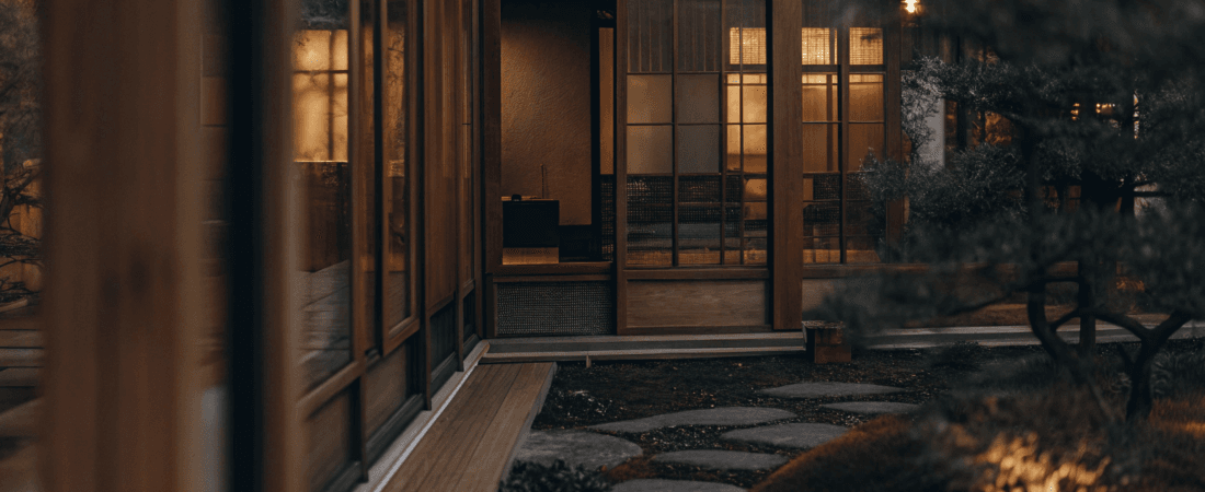 Japanese tiny house design Photograph of a modern wooden house with expansive glass windows nestled in a lush meticulously maintained Japanese style garden with a winding stone path