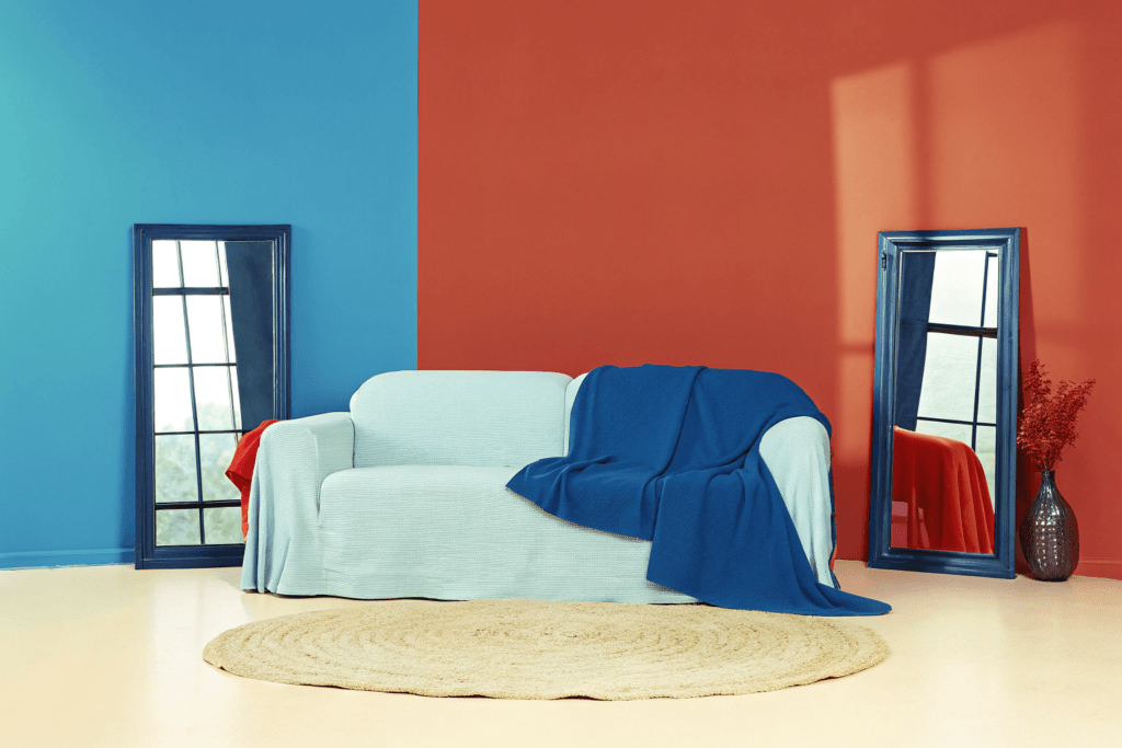 The magic of mirrors Photograph of a serene naturally lit living room featuring a cream slipcover sofa rustic wooden coffee table and natural fiber rug creating a cozy and inviting atmosphere