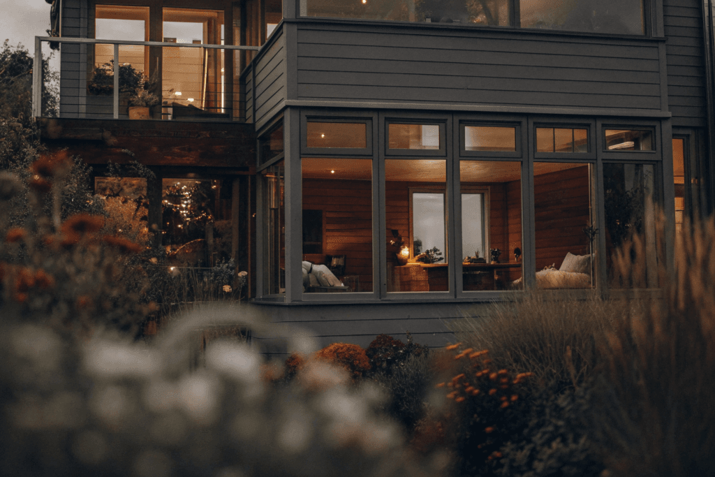 Transformer Photograph of a modern multi story modular home with a vibrant garden showcasing various individuals engaging in daily activities emphasizing sustainable living and versatile spaces