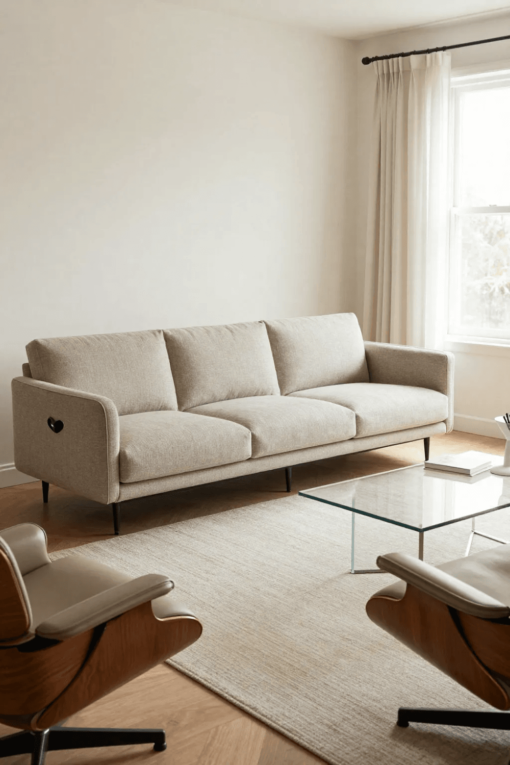 A room with a sofa and lounge chairs