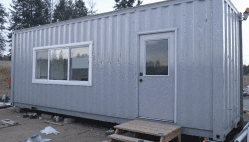 A converted shipping container is being transformed into a tiny home showcasing the innovative process of creating a custom build that maximizes living space while minimizing carbon footprint This tiny house model demonstrates high quality materials and craftsmanship offering several options for families looking to own an affordable and stylish home