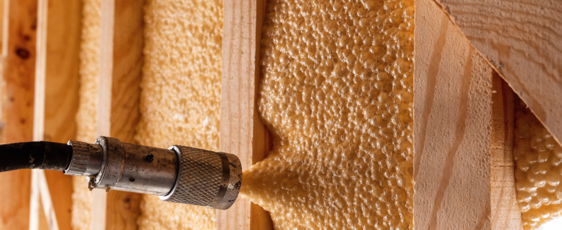 Cell spray foam Close up of expanding foam insulation between wooden studs with a metal pipe fitting in the foreground