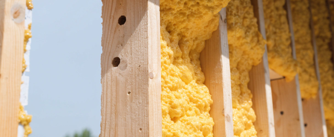 Tiny house wall cavity Expanding yellow spray foam insulation filling wooden stud framing in a wall
