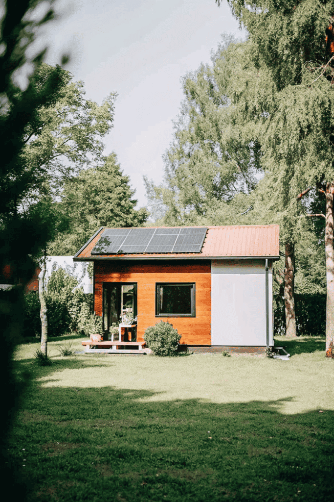 Ecofriendly tiny house with solar panels Tiny house with solar panels on roof in lush green yard